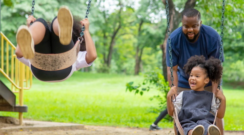 This image: A family enjoying a swing set in a park.
					 	The map:  A closer view of the map with designs for the proposed roads and areas for the project and popups for more information.